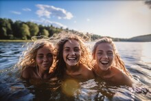 Happy Three Teenage Girls Swimming In A Lake.