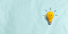 Yellow Light Bulb With Happy Face - Flat Lay