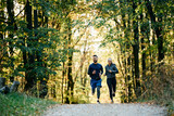 Fototapeta Kwiaty - Happy couple of athletes jogging while working out in park.