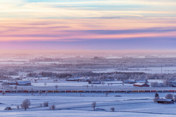 Sticker - Wintry countryside view at dusk with a train