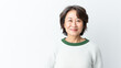 Medium shot portrait of a asian woman in her 50s wearing a cozy sweater against a white background.


