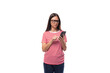 young pretty european brunette woman dressed in a striped t-shirt chatting on the phone in social networks on a white background