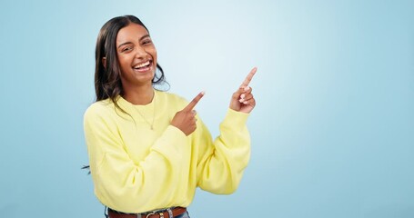 Poster - Happy, dance and face of woman with hand pointing in studio for deal, giveaway or promo on blue background. excited, news and portrait of Indian female model show sale, discount or prize announcement