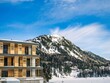 Facade of a hotel with balconies in a ski resort, winter, alps, mountain peak