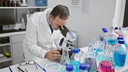 Wall Mural - Upset middle age man with grey hair, stressed scientist working at the lab, worried about his microscope discovery