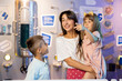 © rh2010 - Portrait of a happy mom with her young kids visiting together a science museum. Concept of children's education and entertainment