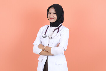 asian muslim beautiful female doctor in white coat with stethoscope, waist up. Woman hospital worker looking at camera and smiling