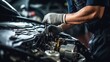 © ttonaorh - Auto mechanic working on car engine in auto repair shop. Car service and maintenance concept.