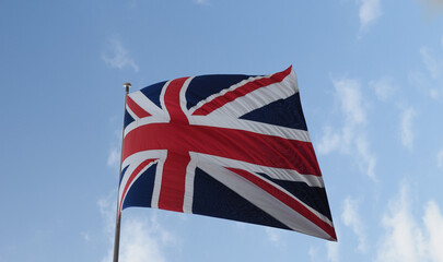 Wall Mural - Union Jack flag of the United Kingdom over blue sky