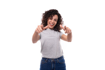 positive slim curly brunette promoter woman with glasses is dressed in a gray basic t-shirt with an identity print mockup on a white background with copy space