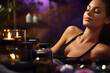 © pilipphoto - Young woman relaxing and enjoying in spa with candles, massage and aromatherapy