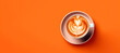© Elena Uve - Banner of cup of coffee with latte art over orange background and copy space. Top view photo.