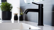 Close up of a black chromed water tap. Running water in the bathroom or kitchen with sink. Hygiene concept.