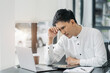© NINENII - Stress businessman is sitting at table, under stress from working.
