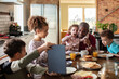 © Marko Geber - Family Fun at Breakfast Time. Father sitting with children in kitchen looking at tablet