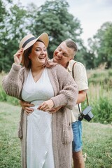 Vertical portrait of happy laughing married couple on summer day in nature. Harmonious family. 