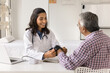 © fizkes - Happy beautiful young doctor woman measuring blood pressure of senior Indian patient, examining elder man with hypertension complaints, using medical electronic measurement device