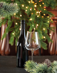 Wall Mural - Christmas background. A bottle of wine and a glass on a background of fir branches