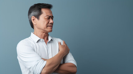 diseases and illnesses - man with face distorted in pain holds one hand at his neck,shoulder or upper arm