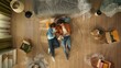 Top view of apartment living room. Man and woman laying on the floor in new apartment looking at color palette choices.