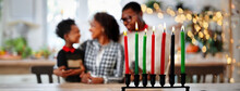 Kwanzaa African American Holiday Candles Kinara With Family Celebrating Harvest Festival On Background. Close-up Of Culture Traditional Decorations. Symbols Of The Seven Principles.