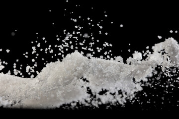 Wall Mural - Salt powder pour fall in bowl, white Salt crystal cook abstract cloud fly. Ground salt splash in air, food object element design. Black background isolated selective focus blur