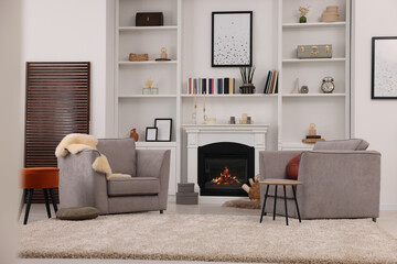 Wall Mural - Comfortable armchairs, fireplace and shelves in living room. Interior design