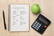 Notebook with products of low, moderate and high glycemic index, pen, calculator and apple on wooden table, flat lay