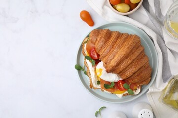 Wall Mural - Tasty croissant with fried egg, tomato and microgreens served on white table, flat lay. Space for text