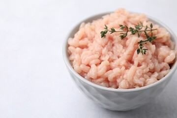 Wall Mural - Fresh raw minced meat and thyme in bowl on light grey table, closeup. Space for text