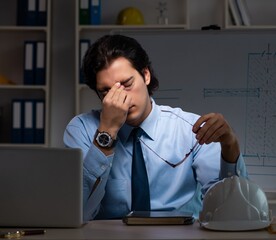 Wall Mural - Young male architect working night at office