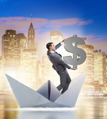 Wall Mural - Businessman holding dollar riding paper ship boat