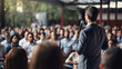 © Nataliya - Motivational speaker with headset performing on stage with microphone in haand, back view
