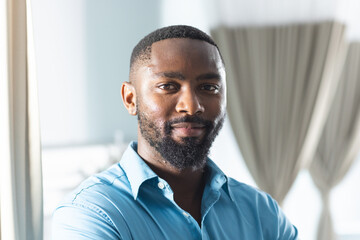 Wall Mural - Portrait of happy african american male doctor in sunny hospital room