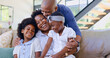 © Charlize D/peopleimages.com - Happy family, children and hug on sofa in living room for bond, embrace and together. Black man, woman and girl with laugh for funny joke, story or memory with love, care and relationship in home