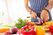 © Wavebreak Media - Hands of happy biracial man in apron chopping vegetables in sunny kitchen at home