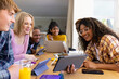 © Wavebreak Media - Happy diverse group of teenage friends studying with laptop and tablets at table at home