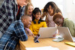 © Wavebreak Media - Happy diverse group of teenage friends studying with laptop and tablets at table at home