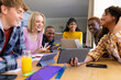 © Wavebreak Media - Happy diverse group of teenage friends studying with laptop and tablets at table at home