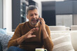 © Wavebreak Media - Senior biracial man sitting on couch and talking on smartphone at home