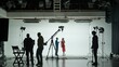 © kinomaster - Professional filming pavilion with a white cyclorama. The process of preparing for the shooting of a music video. Director, Cameraman and crew in Backstage.