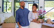 © Charlize D/peopleimages.com - Couple, flowers and happy in new home or real estate with property investment, fresh start and support. Black people, man and woman with pot plant for moving, mortgage and excited for achievement