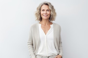 Portrait of a satisfied woman in her 40s wearing a chic cardigan against a white background. AI Generation