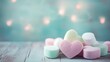 Sweet love story: Pink heart-shaped marshmallows artfully stacked on a vintage blue wooden table, creating a charming Valentine's concept. Copy space for your sweetest messages