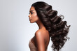 Profile portrait of beautiful brunette African American woman with long, curly and shiny hair