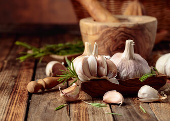 Poster - Fresh garlic bulbs with rosemary on a wooden table.