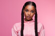 © Surachetsh - The portrait of an attractive young black female model in pink outfit  with braids hairstyle and full makeup isolated on a pink background, shot in a studio. Generative AI.