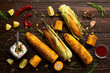 Grilled corn on the cob on kitchen table flat lay background