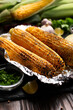 Grilled corn on the cob in tin foil on kitchen table healthy gluten free food background