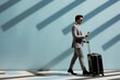 © Rattanathip - Business man and suitcase on abstract background. Business trip concept.